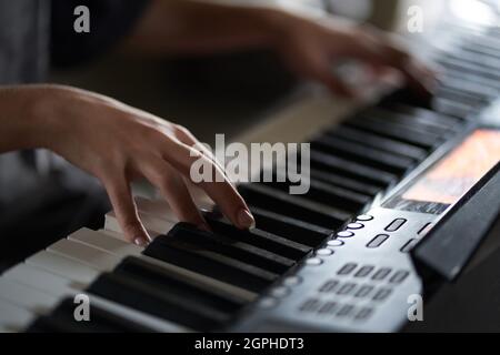 Die Hände des Musikers auf dem Synthesizer. Ein zugeschnittenes Bild einer Person, die einen Synthesizer spielt. Seitenansicht. Hochwertige Fotos Stockfoto