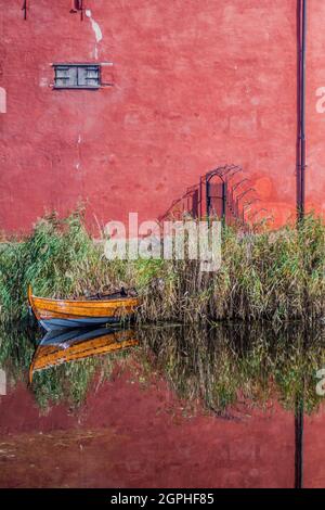 Die Mauern der Burg Malmo und ein kleines Boot, das in einem Wassergraben reflektiert wird, Schweden Stockfoto