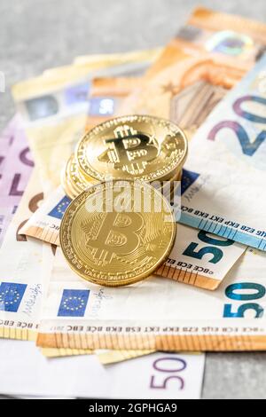 Bitcoins und Euro-Banknoten. Münzen aus Bitcoin. Stockfoto