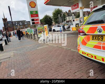 London, Großbritannien. September 2021. Fußgänger laufen an einer Tankstelle in East London vorbei, die von der Polizei bewacht wird, nachdem die Vorräte aufgrund der drohenden Kraftstoffversorgungskrise auslaufen.der RAC (Royal Automobile Club) warnte davor, dass die durchschnittlichen Preise für Benzin 143 Pence pro Liter und für Diesel 145 Pence pro Liter betragen könnten. Gegenüber dem derzeitigen Stand von 135p pro Liter für Benzin und 138p pro Liter für Diesel. ?der höchste Durchschnittspreis für Benzin liegt bei 142 Pence pro Liter, was im April 2012 verzeichnet wurde. (Bild: © David Mbiyu/SOPA Images via ZUMA Press Wire) Stockfoto