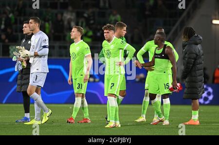 Wolfsburg, Deutschland. September 2021. Fußball: Champions League, VfL Wolfsburg - FC Sevilla, Gruppenphase, Gruppe G, Matchday 2 in der Volkswagen Arena. Gian-Luca Waldschmidt (Mitte) von Wolfsburg und seine Teamkollegen stehen nach dem Spiel enttäuscht auf dem Platz. Quelle: Swen Pförtner/dpa/Alamy Live News Stockfoto