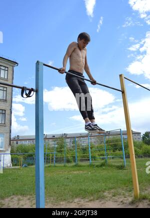 Kovrov, Russland. 11. Juni 2017. Teen ist in Disziplin Gimbarr auf einer horizontalen Bar im Schulhof beschäftigt Stockfoto