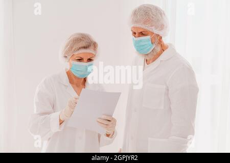 Ärzte mit Gesichtsmaske arbeiten im Krankenhaus zusammen Stockfoto