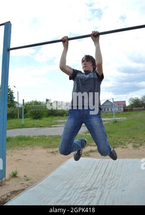 Kovrov, Russland. 11. Juni 2017. Teen ist in Disziplin Gimbarr auf einer horizontalen Bar im Schulhof beschäftigt Stockfoto