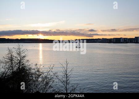 Eine einsame Segelyacht auf dem Cardiff Bay Barrage See bei Sonnenuntergang. Wales UK, Tageslicht Stockfoto