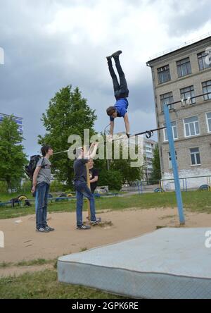 Kovrov, Russland. 11. Juni 2017. Teen ist in Disziplin Gimbarr auf einer horizontalen Bar im Schulhof beschäftigt Stockfoto