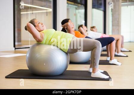 Reife weibliche Durchführung Satz von Übungen mit Pilates Ball Stockfoto