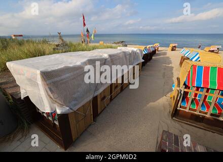 Timmendorfer Strand, Deutschland. September 2021. Liegen, teilweise bereits wetterfest verpackt, stehen an einem Strandzugang an der Promenade von Niendorf. Die Strandliegen-Saison an der Schleswig-holsteinischen Ostseeküste geht zu Ende. Quelle: Christian Charisius/dpa/Alamy Live News Stockfoto