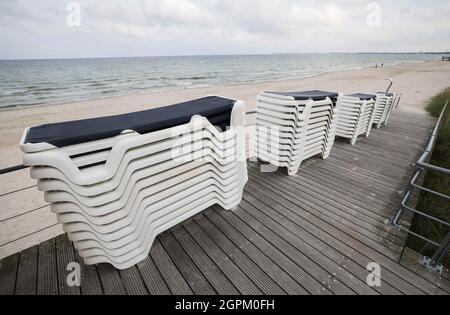 Timmendorfer Strand, Deutschland. September 2021. Gestapelte Strandliegen stehen an einem Strandzugang zwischen Timmendorfer Strand und Scharbeutz. Die Strandliegen-Saison an der Schleswig-holsteinischen Ostseeküste geht zu Ende. Quelle: Christian Charisius/dpa/Alamy Live News Stockfoto