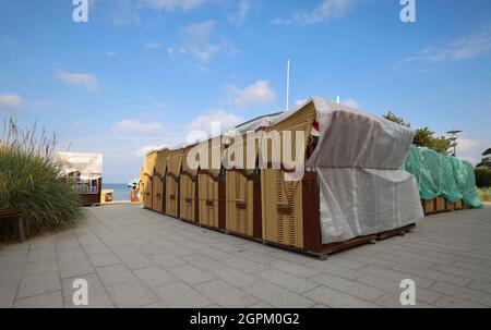 Timmendorfer Strand, Deutschland. September 2021. Liegen, teilweise bereits wetterfest verpackt, stehen an einem Strandzugang an der Promenade von Niendorf. Die Strandliegen-Saison an der Schleswig-holsteinischen Ostseeküste geht zu Ende. Quelle: Christian Charisius/dpa/Alamy Live News Stockfoto