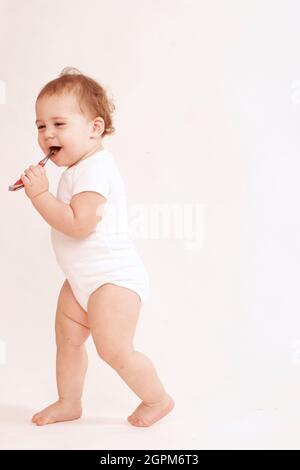 Baby Vollkörper glücklich mit Zahnbürste Stockfoto