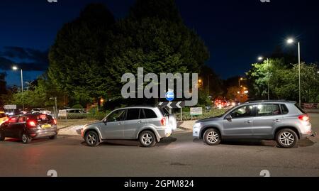 Apsley, Hertfordshire, Großbritannien. September 2021. Am frühen Abend im Dunkeln stehen die Autofahrer an der Tankstelle Apsley von Sainsbury an, um sich zu füllen. Autos, die anstehen, um ihre Tanks zu füllen, sind im Dunkeln mit ihren Lampen von Stoßstange zu Stoßstange, die auf einem Kreisverkehr der A4251 stehen und Verkehrschaos verursachen. Frühere Autofahrer hatten sich schon einige Zeit in der Schlange gestellt, bevor ein Tanker, der bleifreies E10-Benzin lieferte, seine Ladung abgab. Viele Tankstellen in Hertfordshire und den umliegenden Grafschaften wurden geschlossen. Kredit: Stephen Bell/Alamy Stockfoto