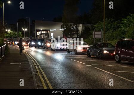 Apsley, Hertfordshire, Großbritannien. September 2021. Am frühen Abend im Dunkeln stehen die Autofahrer an der Tankstelle Apsley von Sainsbury an, um sich zu füllen. Autos, die anstehen, um ihre Tanks zu füllen, sind bei anschallen Lichtern im Dunkeln von Stoßstangen zu Stoßstangen, was auf dem A4251 für Chaos sorgt. Frühere Autofahrer hatten sich schon einige Zeit in der Schlange gestellt, bevor ein Tanker, der bleifreies E10-Benzin lieferte, seine Ladung abgab. Viele Tankstellen in Hertfordshire und den umliegenden Grafschaften wurden geschlossen. Kredit: Stephen Bell/Alamy Stockfoto