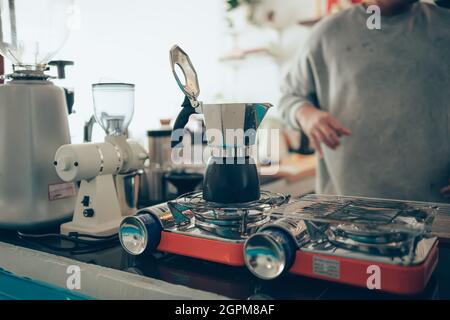 Brauen von schwarzem Moka-Kaffee mit der Moka-Kaffeemaschine und Kochen auf dem Herd. Stockfoto