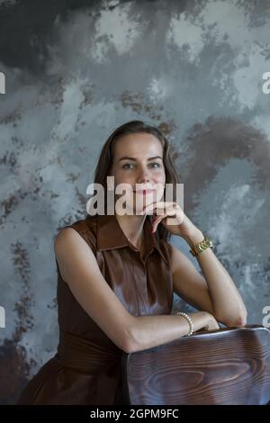 Geschäftsfrau mit braunem Haar in braunem Kleid Stockfoto