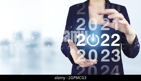 Ladejahr 2021 bis 2022. Konzept starten. Zwei Hand halten virtuelle holographische 2022 Symbol mit hellen unscharfen Hintergrund. Willkommen im Jahr 2022. Business ne Stockfoto