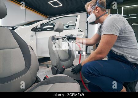 Spezialist Mann führt chemische Reinigung von Innenraum-Sitze Auto Stockfoto