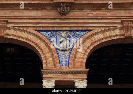SEVILLA, SPANIEN - 21. MAI 2017: Dies ist eines der keramischen Flachreliefs, die die Galerie im unteren Stockwerk des monumentalen Gebäudes im spanischen Quadrat schmücken. Stockfoto