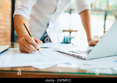 Administrator Geschäftsmann macht Bericht, Berechnung des Saldos. Unternehmen, die Einkommensdiagramme, Grafiken und Daten in der Tabelle analysieren. Stockfoto