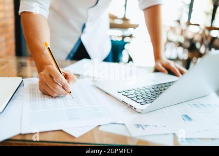 Administrator Geschäftsmann macht Bericht, Berechnung des Saldos. Unternehmen, die Einkommensdiagramme, Grafiken und Daten in der Tabelle analysieren. Stockfoto
