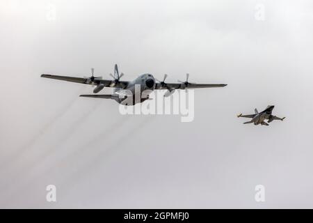 Die belgische Luftwaffe Lockheed C-130H Hercules (REG: CH-01) und F-16C fliegen in Formation entlang der Start- und Landebahn 13. Stockfoto