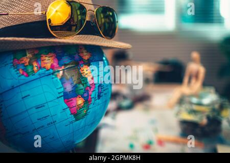 Erdglobus trägt Strohhut und Sonnenbrillen. Weltreisekonzept. Stockfoto