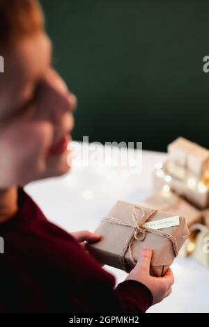 Kinderhände mit Weihnachtsgeschenk-Box, ökologisches Weihnachtsfest-Konzept, Öko-Dekor. Keine Abfälle, umweltfreundliche Verpackung. Hohe Qua Stockfoto