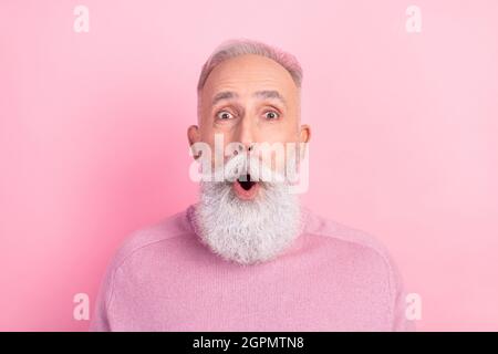 Foto von beeindruckt grauen Haaren gealterten Mann tragen rosa Pullover isoliert auf pastellfarbenem Hintergrund Stockfoto