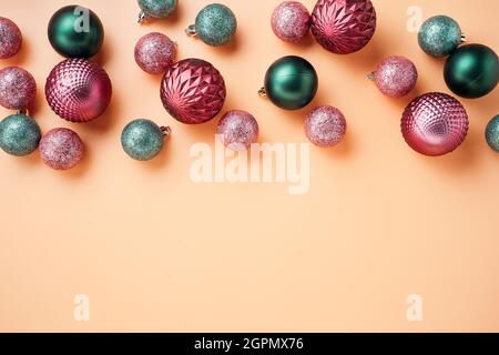 Pinke und grüne Weihnachtskugeln auf Retro-Orange-Hintergrund Stockfoto