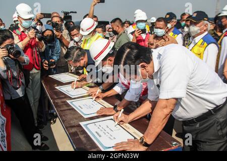 Cileunyi, Indonesien. September 2021. Der koordinierende Minister für maritime Angelegenheiten und Investitionen, Luhut Binsar Pandjaitan (R), das Ministerium für öffentliche Arbeiten und Wohnungsbau, Basuki Hadimuljono (zweiter rechts oben) und der Verkehrsminister Budi Karya Sumadi (zweiter rechts), schreiben während eines Arbeitsbesuchs in Cileunyi Interchange. Die drei Minister hatten die Gelegenheit, das Austauschprojekt Cileunyi und das Nationale strategische Projekt der Mautstraße Cileunyi-Sumedang-Dawuan (Cisumdawu) zu überprüfen. Kredit: SOPA Images Limited/Alamy Live Nachrichten Stockfoto