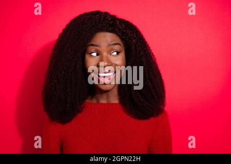 Portrait von attraktiven fröhlich neugierigen Mädchen suchen beiseite kopieren Raum isoliert über lebendige rote Farbe Hintergrund Stockfoto