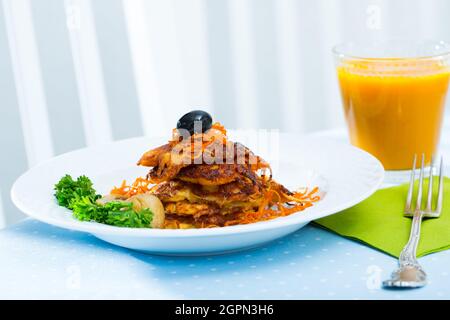 Vegetarische Karotten-Patties mit einem Glas frisch gepresstem Karottensaft. Stockfoto