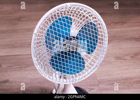 Kleiner Ventilator auf dem Holzboden aus nächster Nähe Stockfoto