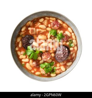 Asturiana fabada mit Haricot, Morcillas oder Blutwurst in grauer Schale isoliert auf weiß. Blick von oben. Traditionelle spanische Küche. Stockfoto