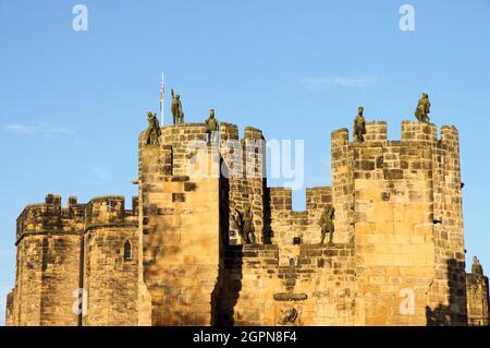 Alnwick Castle barbican Türme mit Statuen kurz vor Sonnenuntergang in Alnwick, Northumberland, England Stockfoto