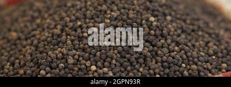 Schwarzer runder Pfeffer auf der Theke des Marktes Stockfoto