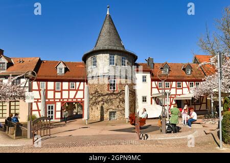 Hofheim, Deutschland - März 2021: Kleiner Stadtplatz mit Turm namens 'Untertor' und Teil der alten historischen Stadtmauer Stockfoto