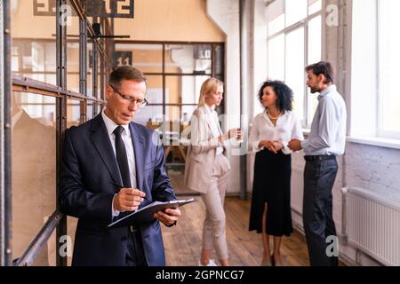 Multiethnisches Unternehmensteam im Büro für einen strategischen Marketingplan - Büroangestellte, Unternehmer und Mitarbeiter des Unternehmens bei der Arbeit Stockfoto