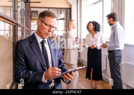 Multiethnisches Unternehmensteam im Büro für einen strategischen Marketingplan - Büroangestellte, Unternehmer und Mitarbeiter des Unternehmens bei der Arbeit Stockfoto