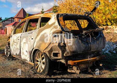 Ausgebrannte Autos stehen im Herbst auf der Straße. Stockfoto