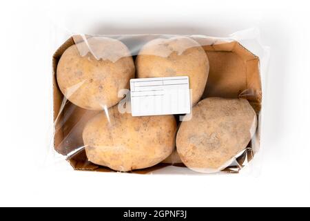 Frisch geerntete Kartoffeln in einer beschrifteten Packung auf weißem Hintergrund Stockfoto