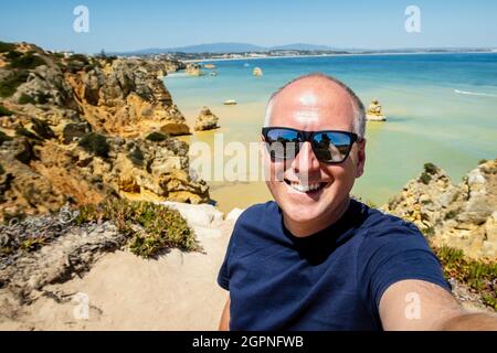 Tourist, der sich selbst im berühmten Ponta da Piedade, Algarve, Portugal fotografiert Stockfoto