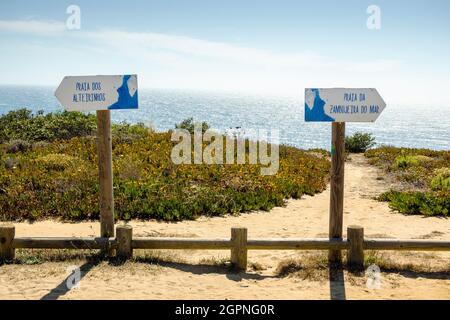 Schilder, die über zwei Strände namens Alteirinhos und Zambujeira do Mar in der Küste von Vicentina, Portugal, informieren Stockfoto