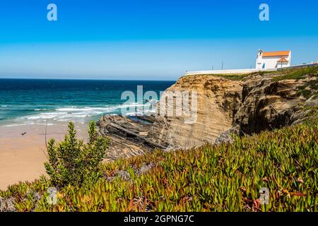 Strand und Kapelle auf der Klippe in Zambujeira do Mar, Alentejo, Portugal Stockfoto