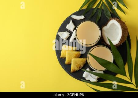 Pina Colada Cocktails und Zutaten auf gelbem Hintergrund. Stockfoto