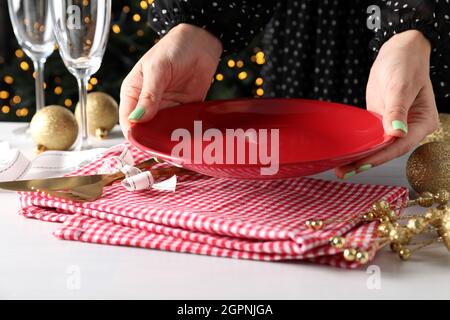 Mädchen macht Neujahrstisch Einstellung auf weißem Tisch. Stockfoto