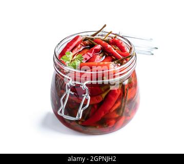 Rot würziger marinierter Chilischote im Glasgefäß, auf Weiß isoliert Stockfoto