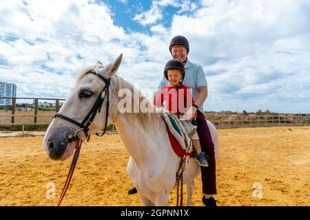 Vater und Sohn genießen Reiten im Paddock Stockfoto