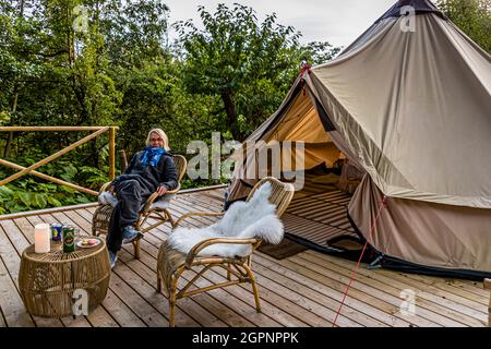 Glamping im Garten der Villa Skovly (Beths Hus). Für die kühlen Abende in Fünen, Dänemark, werden im Glamping-Zelt dicke Jumpsuits aus Fleece bereitgestellt Stockfoto