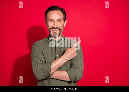 Foto Porträt Mann trägt Freizeitkleidung zeigt Copyspace isoliert lebendige rote Farbe Hintergrund Stockfoto
